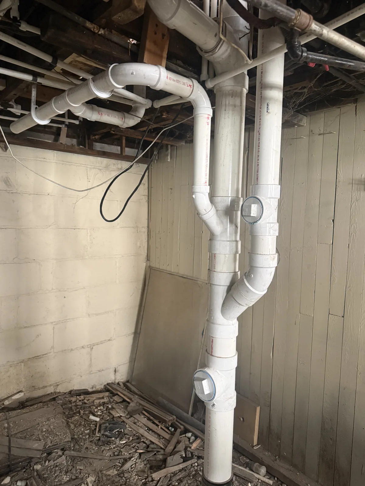 Basement PVC main drain stack with cleanout fittings