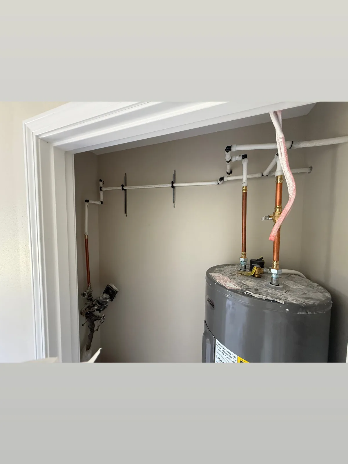 Tank water heater installed in a utility closet