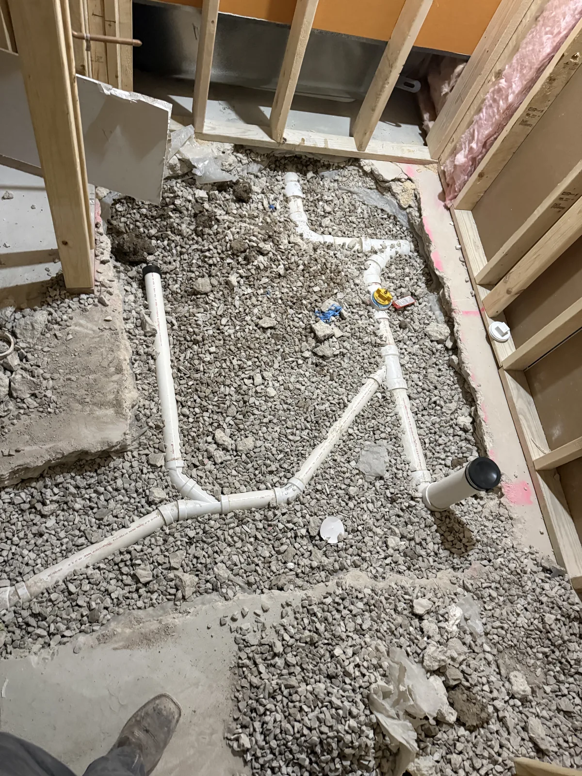 Underground PVC drain lines laid in a trench under slab